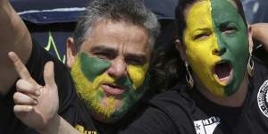 With their faces painted with the colours of Brazil,demonstrators shout slogans during a race in support of Jair Bolsonaro.