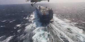 A Houthi helicopter approaches a cargo ship in the Red Sea.