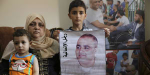 Amro el-Halabi,7,holds a picture of his father,Mohammed,who was the Gaza director of World Vision,now found guilty of diverting sums to Hamas that exceed its total budget.