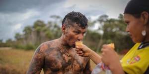 FARC rebel couple Camila gives her boyfriend Cristobal an ice cream as he plays soccer in the mud following a guerrilla conference in the remote Yari plains on Sunday.