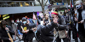 Indigenous protesters do a traditional dance on Bourke Street.