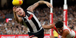 Jack Crisp of the Magpies and Justin McInerney of the Swans compete for the ball