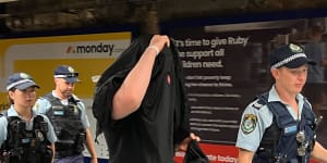 A man is escorted from North Sydney railway station on Australia Day.