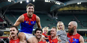Jack Viney of the Demons is carried off for his 200th game. Max Gawn is on the far right side.