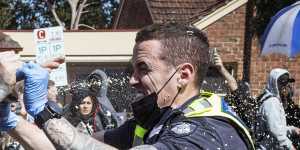 A police officer uses capsicum spray on a protester during Melbourne’s anti-lockdown rally. 