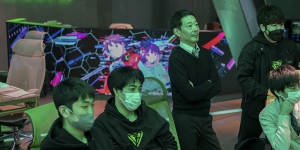 Staff watch as students compete in a video game tournament at Japan’s first eSports high school in Tokyo.