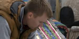 A Russian man rests in at temporary accommodation facility after crossing the border into Kazakhstan.