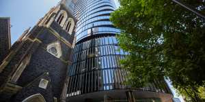 Wesley Place towers loom over a historic church on Lonsdale Street.