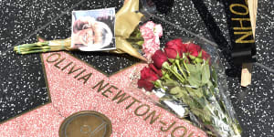 Fans leaving flowers on Olivia Newton-John’s Hollywood Walk of Fame star.
