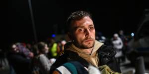 A man carries a sleeping child across the Polish border from Ukraine on February 25.