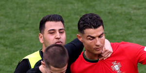 Cristiano Ronaldo tries to get away from a pitch invader.