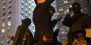 Protesters carry “Liberate Hong Kong,Revolution of Our Times” flags in Hong Kong in 2019.