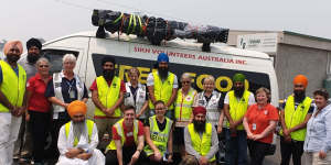 Some members of Sikh Volunteers Australia,on the road. Jaswinder Singh is pictured kneeling,front right.