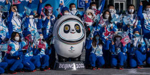 Olympic volunteers pose with the Games’ mascot Bing Dwen Dwen. 