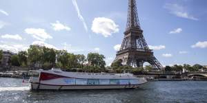 An empty boat travels the river Seine during the technical test event for the Paris 2024 opening ceremony with the Eiffel Tower in the background.