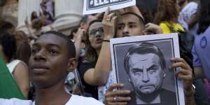 People protest holding signs with a message that reads in Portuguese:"Not him"during a protest against Jair Bolsonaro.