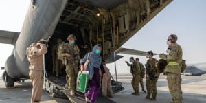 Afghanistan evacuees and Australian soldiers disembark a Royal Australian Air Force C-130J Hercules aircraft at Australia’s main operating base in the Middle East,after their flight from Kabul.