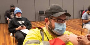 Warehouse worker Daniel Matcham rolls up his sleeve to get jabbed at a clinic in Hoppers Crossing.