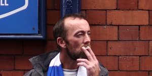 A soccer fan smokes a cigarette outside a pub in Liverpool.