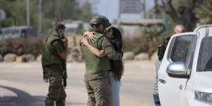 An Israeli soldier kisses his partner as she visits him near the border with the Gaza Strip.