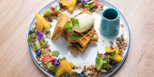Spiced pumpkin waffle encircled by fruit,nuts and seeds.