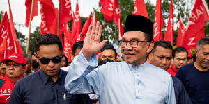 Anwar Ibrahim greets supporters as he arrives to submit his nomination in the seat of Tambun,in Perak state,on Saturday.