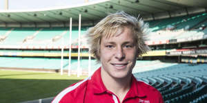 Historic AFL items donated to Sydney Swans displayed by Isaac Heeney and Callum Mills