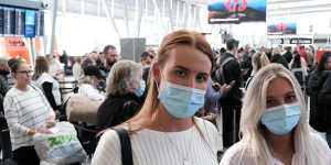 Nicola Kypteos and Maddy Caesar battle lengthy queues at Sydney Airport on Friday morning.