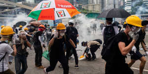 Demonstrators in Hong Kong disperse as the police fire tear gas.