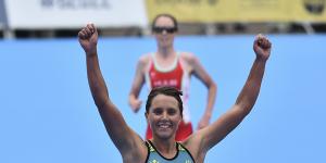 Sophie Linn of Australia raises her arms after completing the women’s individual triathlon.