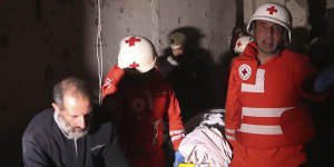 Red Cross volunteers carry one the two bodies of an elderly couple who died when their house was hit by Israeli shelling in the southern town of Chebaa,Lebanon,on Saturday.