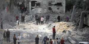 Palestinians inspect the damage of a destroyed house following Israeli airstrikes in the town of Khan Younis.