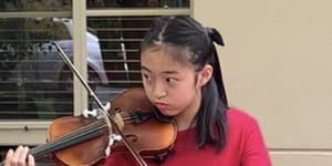 Tiana Ekpanyaskun playing her adapted violin.