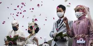 Couples sow flowers as they attend a mass wedding during the pandemic in Yogyakarta.