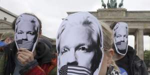 People in Berlin wear masks to protest against Assange’s possible extradition to the US.