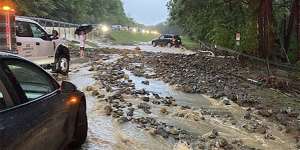 Vehicles come to a standstill near a washed-out and flooded portion of the Palisades Parkway just beyond the traffic circle off the Bear Mountain Bridge on Sunday,July 9,in Orange County,New York.