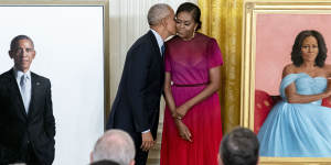 Former president Barack Obama kisses his wife former first lady Michelle Obama after they unveiled their official White House portraits during a ceremony in the East Room of the White House in Washington. 