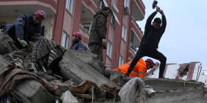 Emergency team members and others search for people in a destroyed building in Adana,Turkey.