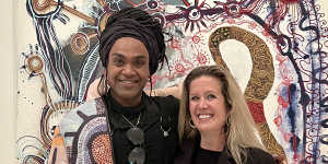 Wynne Prize winner Zaachariaha Fielding (left) and APYACC general manager Skye O’Meara,in front of his Untitled 2020 painting at the National Gallery of Victoria.