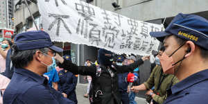 An anti-DPP protester holds up a banner at a political rally in Taipei. 