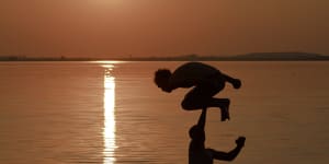 A man jumps into a lake in Bucharest,Romania during a heatwave in July 2015:global temperatures are now about 1.1 degrees warmer than the pre-industrial era and are on track to be more than 3 degrees warmer by the end of this century if carbon emissions are not curbed,the World Meteorological Organization warns.