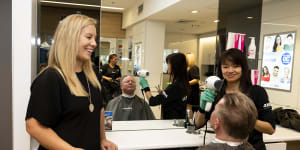 JustCuts CEO Amber Manning watches as regular customer Robert Elder gets a haircut in Randwick,Sydney.