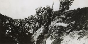 Australian infantrymen clamber out of a trench on the Western Front in France on a bayonet charge towards the German lines.