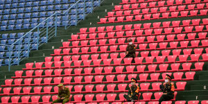 Police officers wearing masks sit in the stands as the Matildas played Vietnam in a match that was closed to the public. 