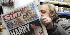 London newsagent Roy Ottoway reads a copy of tabloid ‘The Sun’,whose front page shows Prince Harry wearing a Nazi soldier’s uniform to a fancy dress party in 2005.