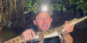 Australian Reptile Park manager Billy Collett with a freshwater crocodile captured at Wallsend on Sunday,March 1,2026.
