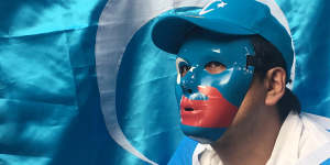 An Uyghur human rights activist wears mask with the colours of the East Turkestan flag during a rally against the Chinese government in Osaka,Japan.