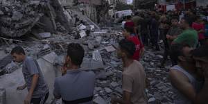 Palestinians look for the injured in the rubble of a destroyed building.