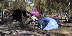 Tents,debris and a burned out van are scattered about the site of a music festival near the border with the Gaza Strip days after October 7.