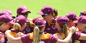 Queensland Fire players in a huddle before playing Tasmania at Allan Border Field this week.
